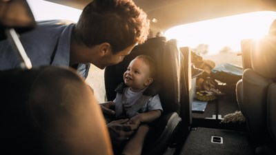Padre abrochando a su hijo en el coche